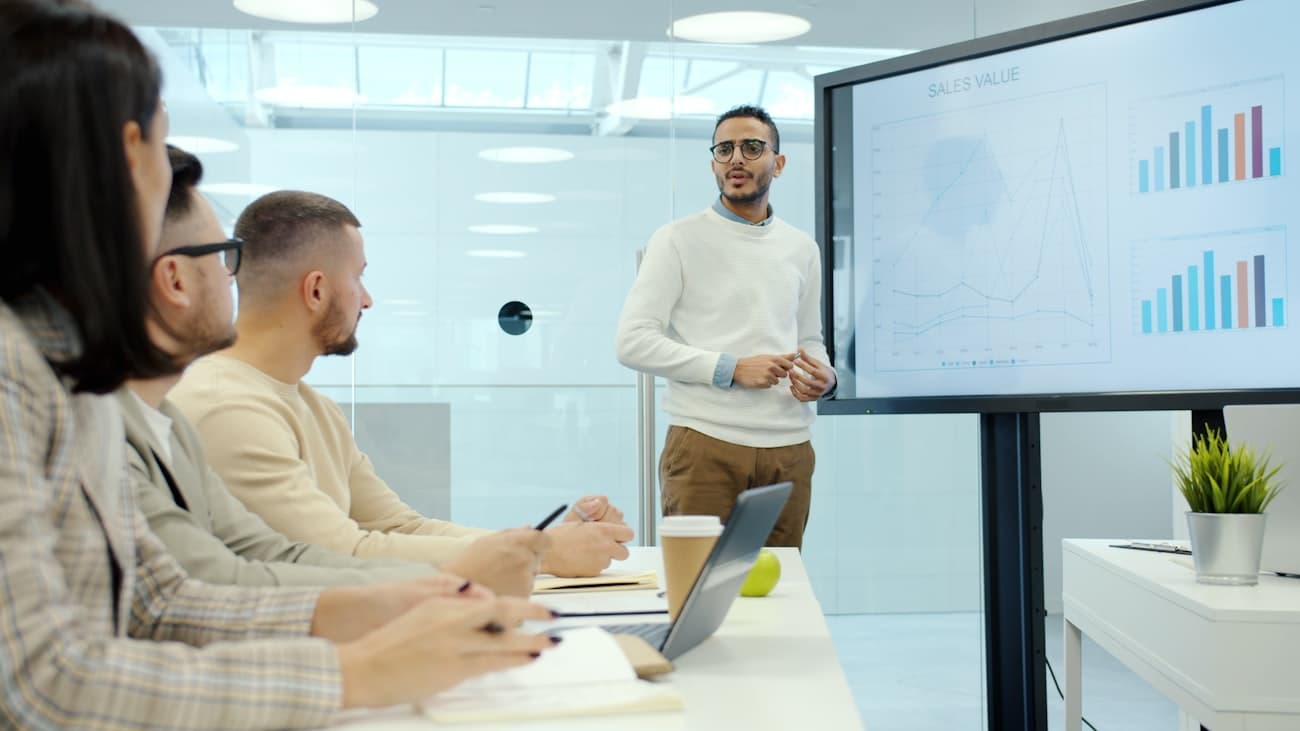 A business student presenting data to engaged classmates in a seminar