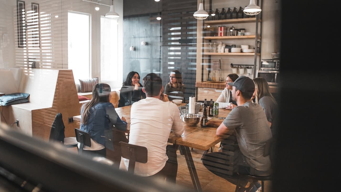 A small mixed team discussing together around a table in a modest office