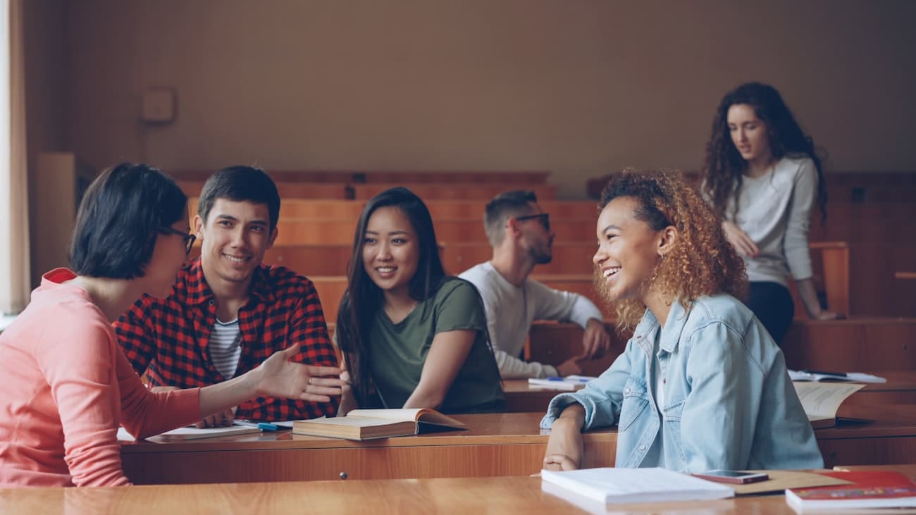 Studenti universitari diversi che studiano insieme in aula
